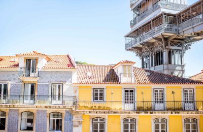 view-old-buildings-with-famous-saint-justa-metal-lift-during-sunny-weather-lisbon-city-portugal-1-scaled